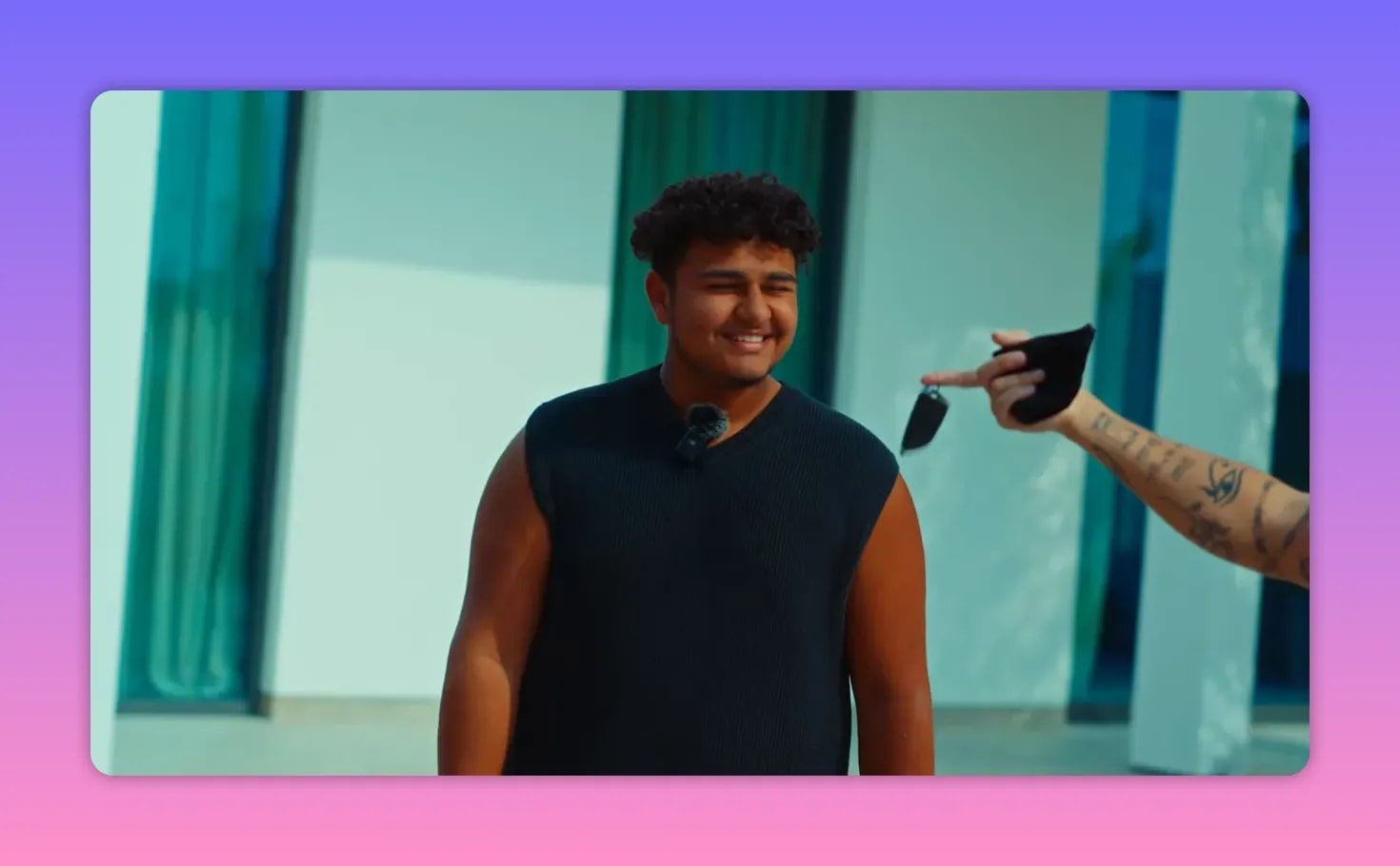 Jeune homme souriant recevant les clés lors du reveal à Dubaï, expression de surprise et joie visible.