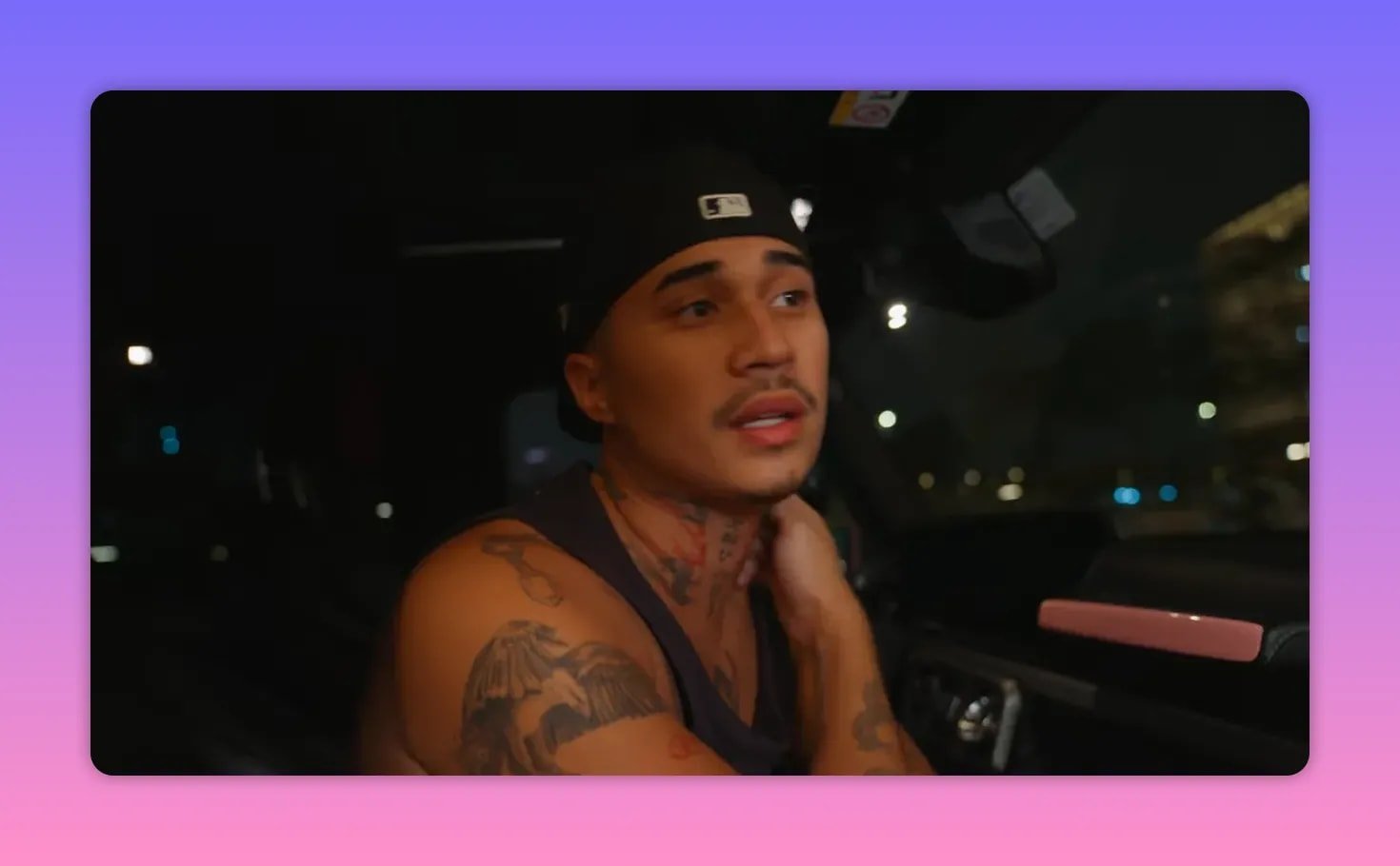 Personne tatouée dans une voiture la nuit, main sur la nuque, air pensif et préoccupé