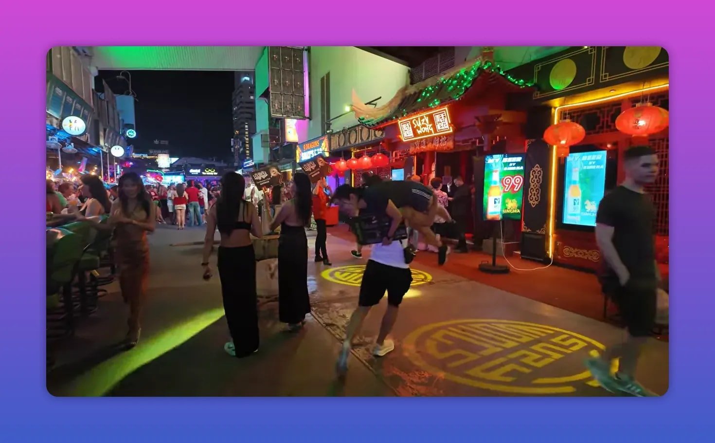 Rue de nuit avec façades rouges lumineuses et écrans le long de Bangla Road
