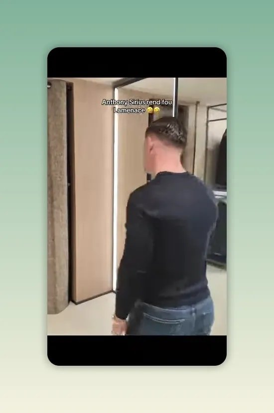 Homme en pull noir marchant vers un rideau de cabine dans une boutique avec miroirs