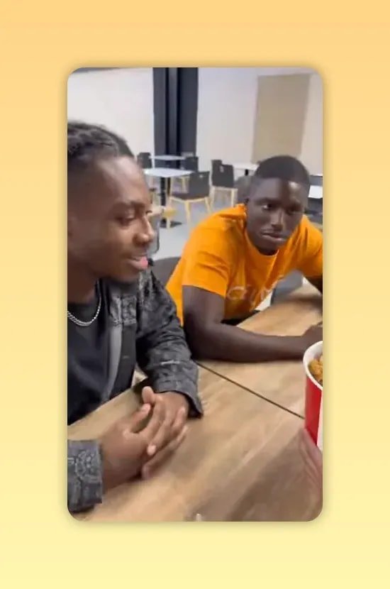 seau de KFC posé sur une table avec un homme en t-shirt orange assis derrière