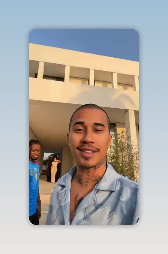 Homme en chemise claire devant une maison moderne avec un autre homme en t-shirt bleu à l'arrière-plan
