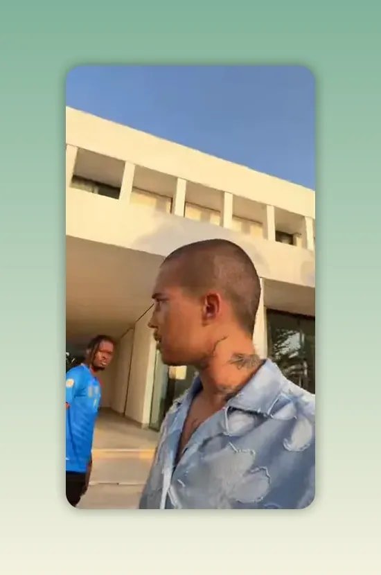Homme de profil au premier plan devant une maison moderne avec un homme en t-shirt bleu plus loin