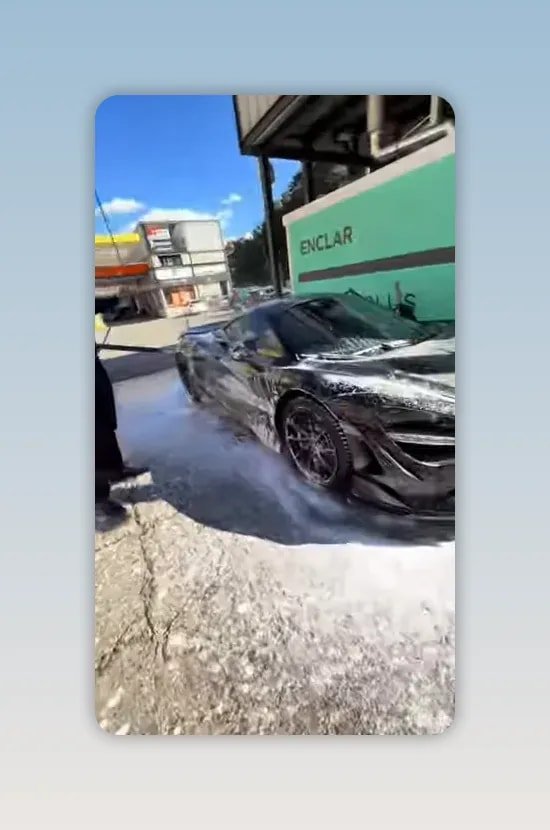 Voiture noire sportive couverte de mousse sur une aire de lavage