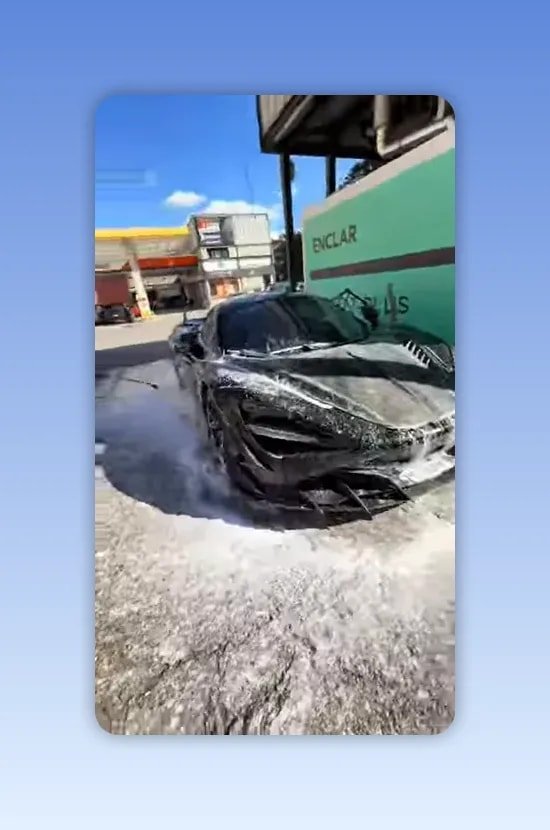 Voiture noire brillante de face dans une station de lavage avec mousse au sol